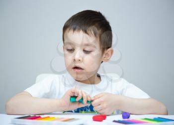 Happy boy playing with color play dough