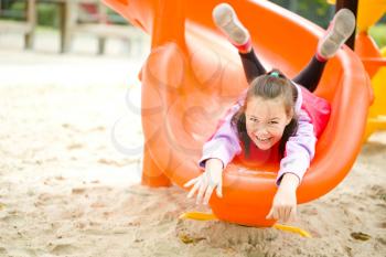 Cute happy girl is playing on playground, outdoor