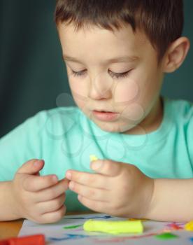 Happy boy playing with color play dough