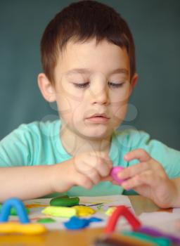 Happy boy playing with color play dough