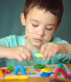 Happy boy playing with color play dough