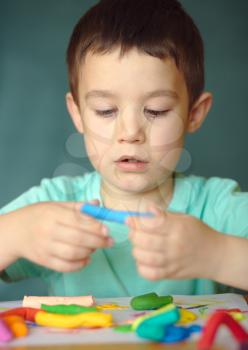 Happy boy playing with color play dough