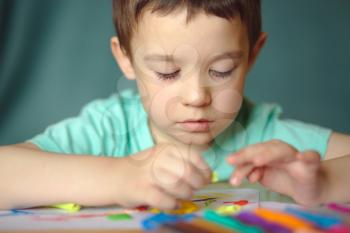 Happy boy playing with color play dough