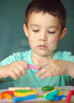 Happy boy playing with color play dough