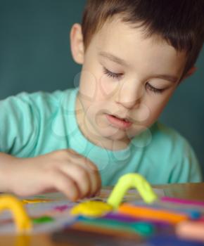 Happy boy playing with color play dough