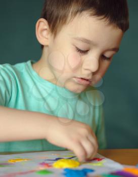 Happy boy playing with color play dough