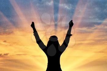 Emotion of happiness. Silhouette of a happy man with his hands raised in the sunset background