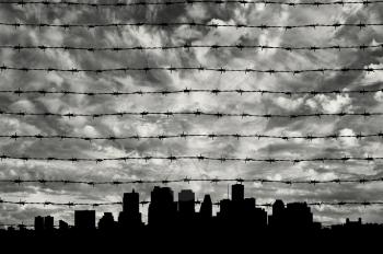 Border Zone concept. Silhouette of the barbed wire on the background of the urban landscape