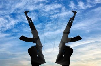 Terrorist concept. Weapons in the hands of terrorist, against the sky