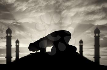 Religion Islam. A Muslim prays at sunset near the mosque