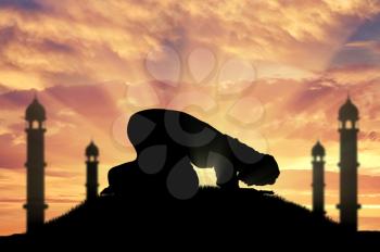 Religion Islam. A Muslim prays at sunset near the mosque