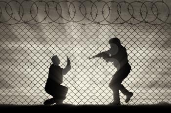 Terrorism concept. Terrorist attack on a peaceful man near the fence of barbed wire