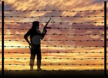 Terrorism and conflict. Armed terrorists near the fence of barbed wire