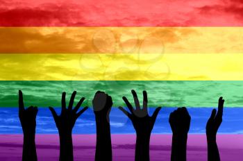 Silhouette of hands of people the gay parade and the LGBT movement on the background of rainbow flag