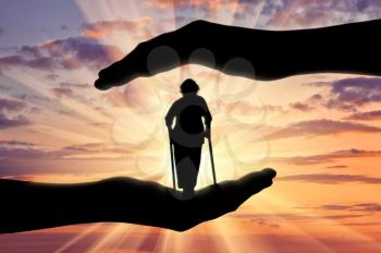 Disabled woman stands on crutches in hands sunset. Concept protection of disabled persons