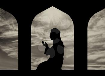 The concept of the Islamic religion. Silhouette of man praying at the Town Hall