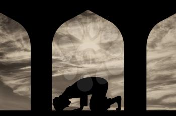 The concept of the Islamic religion. Silhouette of man praying at the Town Hall