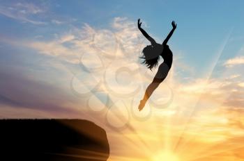 Concept of happiness and freedom. Silhouette of happy woman jumping at sunset