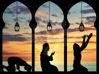 concept of the Islamic religion. Silhouette of praying Muslims in the background of the sea sunset