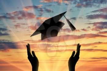 Hands graduate cap throw up into sky sunset. Study concept