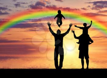 Gays and family. Pair of gay men and their children playing at sunset on the sea with a rainbow