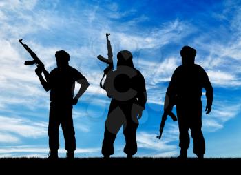  Silhouette of three terrorists with a weapon against a background of blue sky