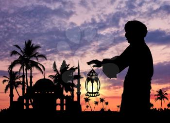 ?oncept of Islamic culture. Silhouette of a man with a lamp in his hand against the sunset