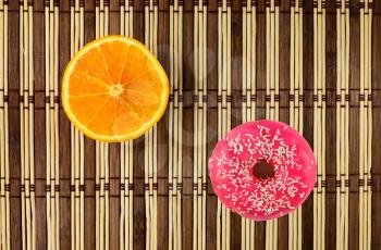 Donuts in pink frosting and orange fruit. design element