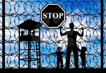 Concept of refugee. Silhouette of father and child refugees and fence with barbed wire and watch tower