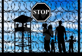 Concept of refugee. Silhouette of a family with children of refugees and fence with barbed wire and watch tower