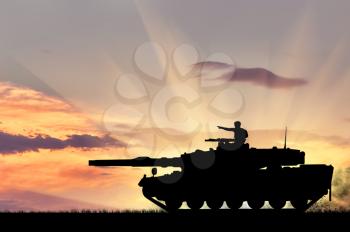 Concept of war. Silhouette of a tank with a soldier at sunset