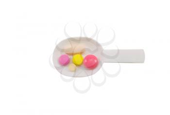 Concept of health and medicine. A set of tablets in a plastic spoon isolated on white background