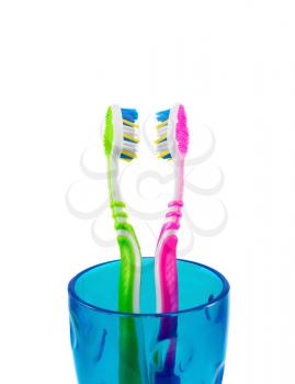 Two toothbrushes in a blue cup isolated on white background