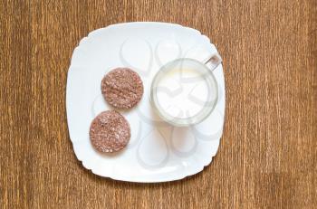 Concept of a light breakfast. Chocolate cookies with a glass of milk on a plate