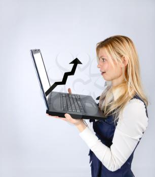Concept of profit. Surprised woman holding a laptop with a positive schedule