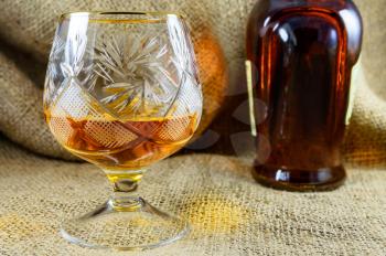 Aged whiskey in a crystal glass beside the bottle. design element