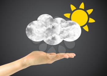Concept of the weather and partly cloudy. Icon sun with clouds in the man's hand