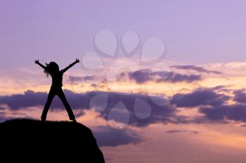 Silhouette of the happy woman on a hilltop in the evening. happiness and success concept