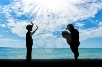 Fat boy and a normal boy playing ball near sea. concept of childhood obesity