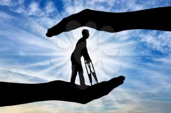 Silhouette of a disabled man with crutches in the hands of help. The concept of protection and assistance to people with disabilities