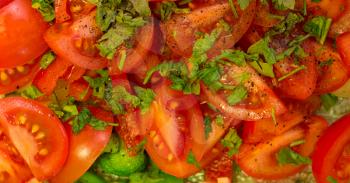 Salad of cherry tomatoes with parsley, broccoli and black pepper. Close-up.