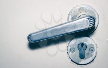 Door handle and keyhole. Sharpness on the door handle. Photo toned.