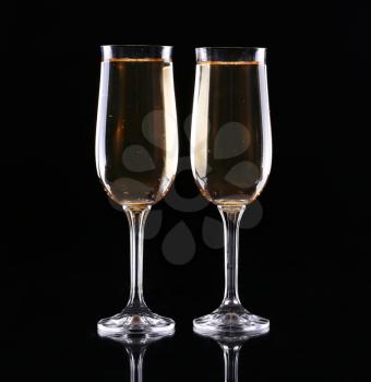 two glasses of champagne over black background