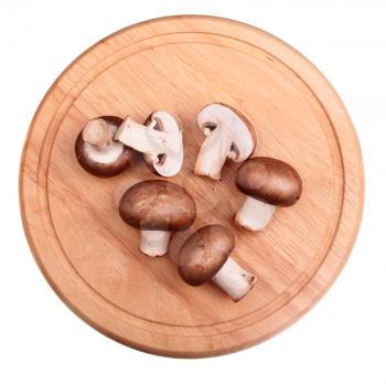 Brown champignon mushroom isolated on wooden board