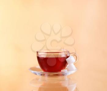  Cup of tea on glass with orange background