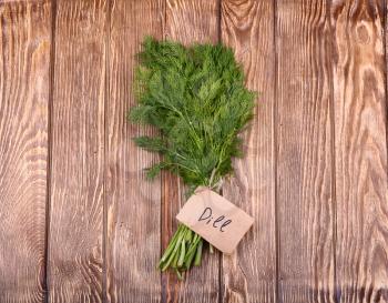 Fresh green dill on old wooden background