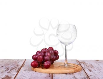 Glass and grapes isolated on a white background on a wooden board