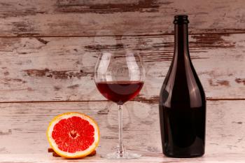 glass of red wine, a bottle of wine and grapefruit on the tablets