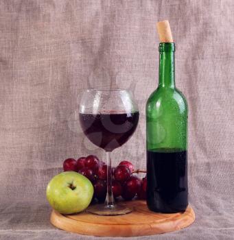 Red wine, cheeses and grapes in a still life setup.