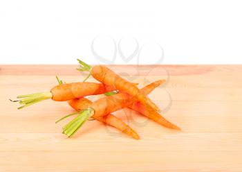 Freshly washed whole carrots on old wooden table